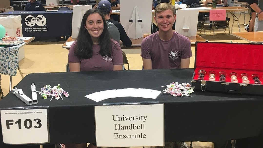 two people attending a handbells activity fair booth